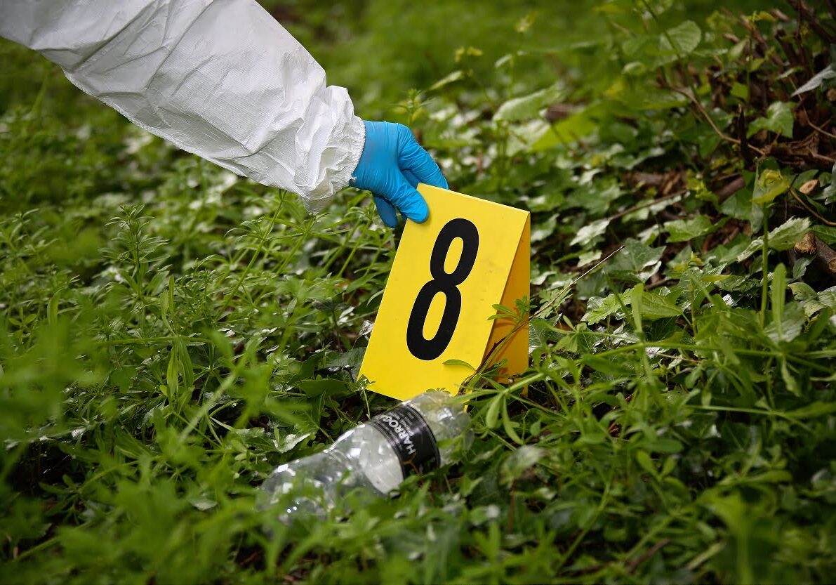 CSIs at work Crime scene number 8 being placed on the ground adjacent to a potential exhibit.